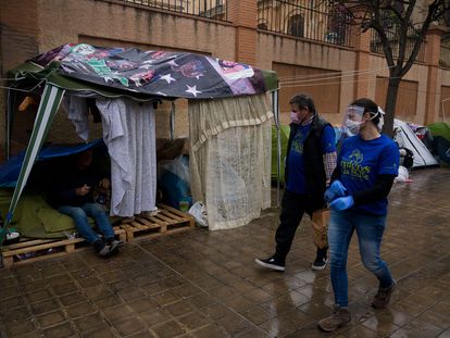 Varios voluntarios reparten comida a personas sin hogar, el pasado jueves en Valencia.