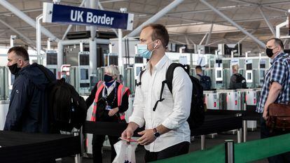 Pasajeros hacen cola en un control de pasaportes del aeropuerto londinense de Stansted, el pasado julio.