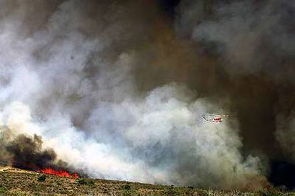 Un helicóptero vuela cerca del área quemada en Santa María del Espino, en la provincia de Guadalajara, donde han sido evacuadas cientos de personas.