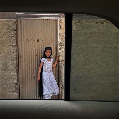 Una niña se asomaba a la puerta de una casa en un pueblo a las afueras de Kandahar. 