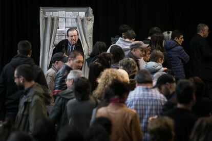 Decenas de personas hacen cola para poder votar en el colegio instalado en las Cocheras de Sants, Barcelona.