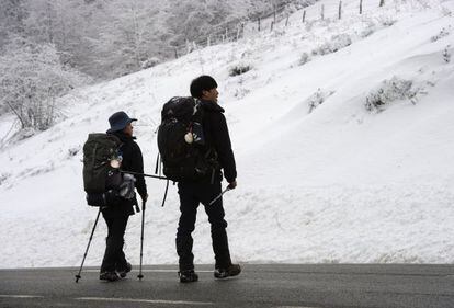 Dos peregrinos llegan al alto de Ibañeta en Navarra.
