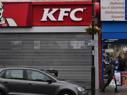 Un peatón camina en Londres este lunes delante de un local de KFC cerrado.