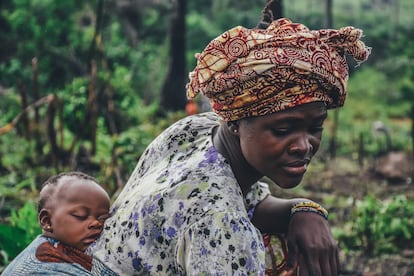Una mujer con su bebé a cuestas en una plantación de yuca en Sierra Leona.