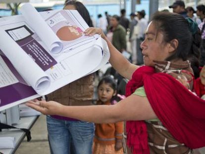 Una vocal de mesa coloca informaci&oacute;n electoral en un colegio en San Lorenzo Tlacoyucan, en la capital mexicana.