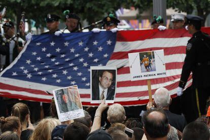 Familiares sujetan fotos de sus seres queridos durante la celebración del decimoquinto aniversario de los ataques del 11 de septiembre 2001, en Nueva York (Estados Unidos).