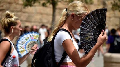 Dos mujeres con abanicos en Sevilla, el lunes.