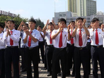 Un grupo de norcoreanos aplaude la orden del líder Kim Jong-un del lanzamiento de prueba del proyectil intercontinental.