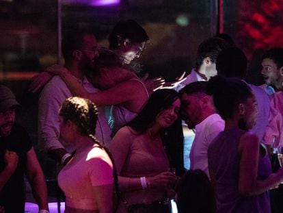 Un grupo de jóvenes toman copas en una de las terrazas de una discoteca de pie de playa de Barcelona, en la primera noche con ampliación horaria hasta las tres de la madrugada.