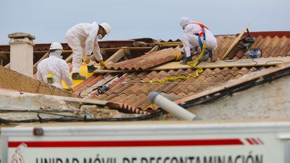 Operarios especializados en la retirada de los tejados de amianto de las tres casas, que se van a derribar en la playa de la babilonia en Guardamar del Segura.