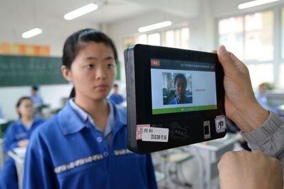 Un profesor utiliza un dispositivo con tecnología de reconocimiento facial para comprobar la identidad de los estudiantes durante una simulación del examen de acceso a la universidad, el 6 de junio del 2017.