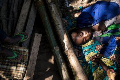Un niño descansa junto a otras personas desplazadas mientras esperan su ración diaria de alimentos en un sitio para desplazados que huyen del conflicto en la provincia de Kasaï, en Kilwit (República Democrática del Congo).