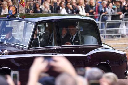 El rey Carlos III llega al palacio de Buckingham, este miércoles por la mañana. Desde el coche, el monarca ha saludado a los miles de personas que se han congregado alrededor del edificio para asistir al cortejo fúnebre.