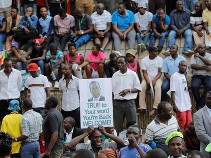 Decenas de zimbabuenses celebran la llegada del exvicepresidente expulsado Emmerson Mnangagwa a Harare este miércoles.
