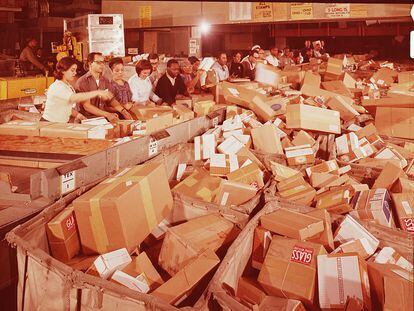 Trabajadores de una empresa postal clasifican paquetes en Navidad.