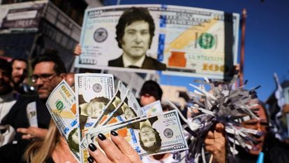 Simpatizantes de Javier Milei agitan reproducciones de dólares con su cara en un mitin celebrado en Buenos Aires.