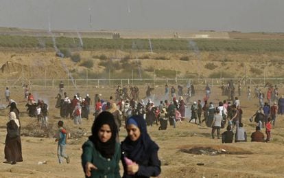 Manifestantes huyen del gas lacrimógeno lanzado por las fuerzas israelíes durante una protesta de mujeres palestinas en la frontera de Gaza.