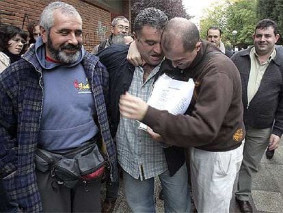Dos trabajadores de Caballito se abrazan emocionados, ayer, tras la firma del acuerdo con la empresa que ha puesto fin a los dos años de huelga.