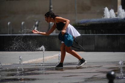 Una chica se refresca en una fuente de Sevilla durante la cuarta ola de calor del verano. 
