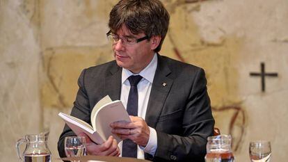 El president Puigdemont hojea el Plan de lectura.