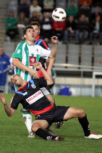 Javier Flores, del Córdoba, lucha con el racingista Ariel por el balón.