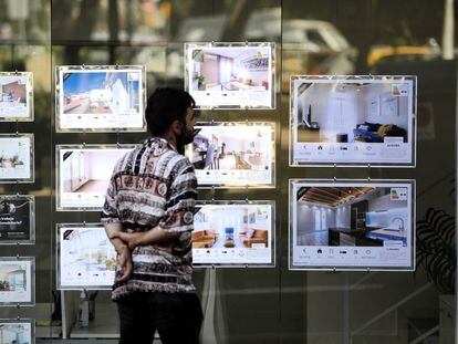 En la imagen un joven mira anuncios de alquiler de una inmobiliaria en Barcelona.