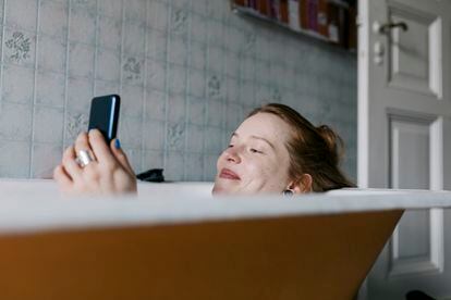 Woman Taking Bath And Smiling While Messaging Someone