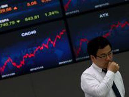 Un hombre reacciona en la sede del Korea Exchange Bank junto a unas pantallas informativas que muestran el &iacute;ndice Kospi en Se&uacute;l (Corea del Sur). EFE/Archivo