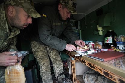 Volodimir (right), commander of a grad missile launch company, prepares something to eat while waiting for the order to fire on the Chasiv Yar front near Bakhmut.