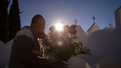 Un hombre sujeta un ramos de rosas en el cementerio de Casabermeja (Málaga), este miércoles.
