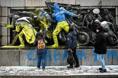 Varias personas pinta con los colores de la bandera de Ucrania un monumento a los soldados soviéticos en Sofía (Bulgaría).