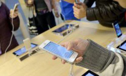 Un comprador observa un nuevo iPhone 5S en una tienda Apple de Nueva York, EE.UU.