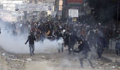 Manifestantes islamistas lanzan piedras y otros objetos contra los polic&iacute;as antidisturbios durante enfrentamientos en El Cairo (Egipto).