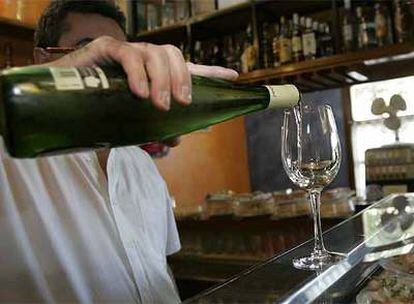 Un camarero sirve una copa de vino en un bar de Vitoria.