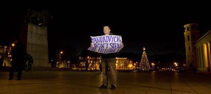 Un hombre lleva una pancarta que reza &quot;&iexcl;Yanukovich: no robes el futuro!&quot; frente al palacio de Vilna donde se celebra la cumbre europea.