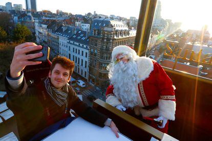 Un 'selfie' navideño en Bruselas. La atracción Santa in the sky (Santa en el cielo) simula el trineo de Papá Noél que es elevado sobre los techos de la ciudad mediante una grúa. En las alturas, los visitantes toman el té o cenan en presencia de Santa.
