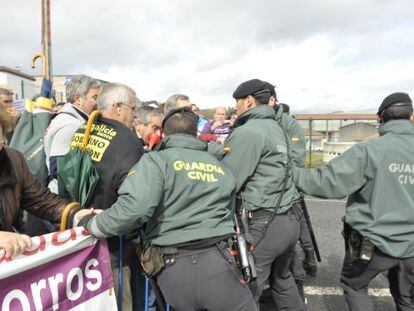 Guardias civiles forcejean con manifestantes para que no traspasen las vallas ante el congreso del PP de Pontevedra, en Silleda.
