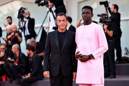 El actor Seydou Sarr, con un bonito conjunto de camisa y pantalón rosa, acompañado del director  Matteo Garrone, que se decantó por un clásico traje negro.

 