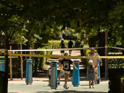 Una familia juega dentro de un área balizada en el parque de El Retiro, el pasado martes.