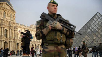 Un soldado armado custodia la entrada del Louvre.