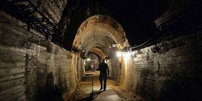 Un home camina per un túnel a l'àrea on es busca un tren nazi.