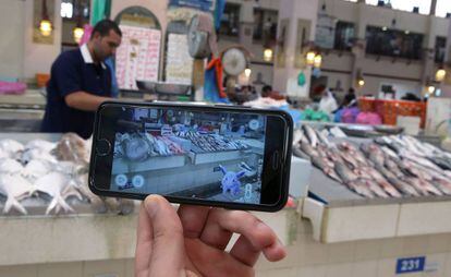 Un jugador usa su Pokémon Go en el mercado principal de pescado de Kuwait.