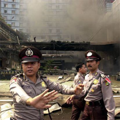 Varios policías indonesios despejan la zona cercana al hotel.