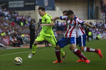 Messi condueix la pilota entre la defensa de l'Atlètic durant el partit de diumenge al Calderón.