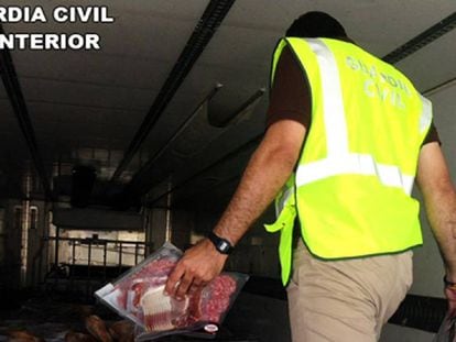Un guardia civil en el interior del camión donde se encontraron miles de jamones caducados.