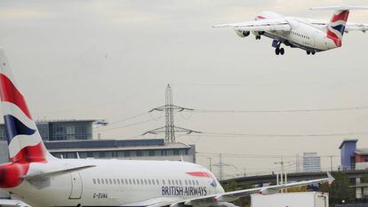Un avión de British Airways -una de las empresas denunciadas por discriminación- espera para despegar, mientras que el otro ya ha despegado.