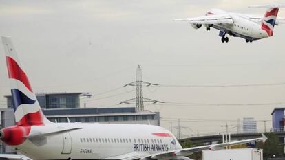 Un avión de British Airways -una de las empresas denunciadas por discriminación- espera para despegar, mientras que el otro ya ha despegado.