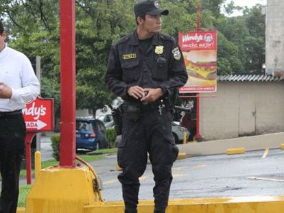 Un polic&iacute;a junto a un ciudadano en San Salvador