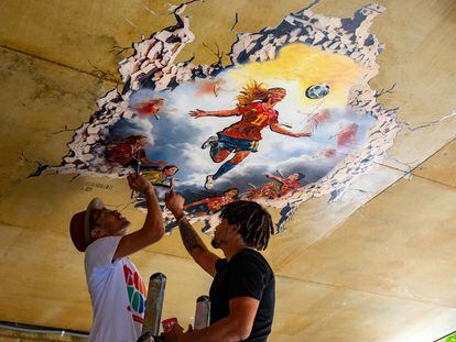 Los artístas Nadiemedicearte y PRËO dan los últimos retoques al mural que representa la victoria de la selección española de fútbol femenino en el Mundial 2023. Kike Rincón.