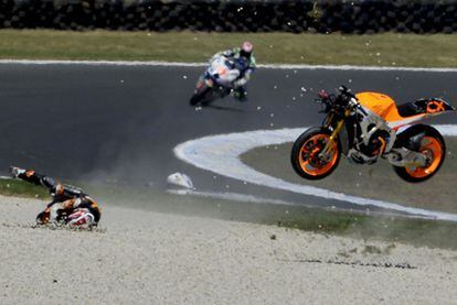 Marc Márquez rueda por el suelo, con su moto en el aire, tras su choque con Ratthapark Wilairot.